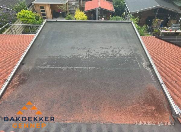 Verouderd plat dak met slijtage tussen schuine daken in Gennep Verouderd plat dak met slijtage tussen schuine daken in Gennep