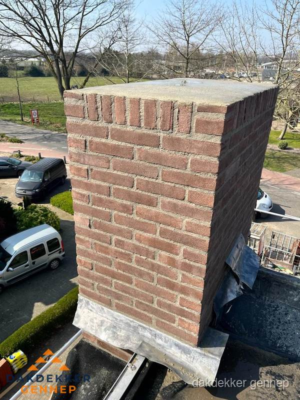 Gemetselde schoorsteen met loodaansluiting op dak in Gennep Gemetselde schoorsteen met loodaansluiting op dak in Gennep