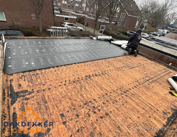 Dakdekker legt onderlaag op plat dak met houten constructie in Gennep