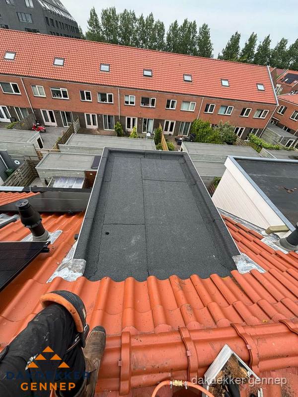 Bitumen dak reparatie op plat dak tussen dakpannen in Gennep