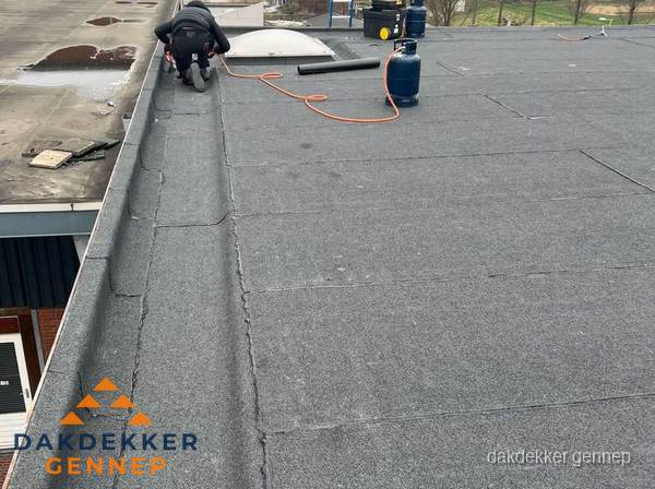 Dakdekker repareert bitumen dakbedekking op groot plat dak in Gennep Dakdekker repareert bitumen dakbedekking op groot plat dak in Gennep